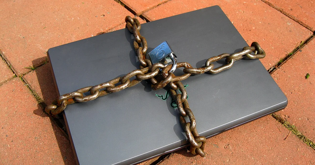 Laptop computer locked with chain and padlock.